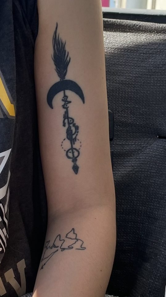 Avant le cover : ancien tatouage de flèche avec une lune, sur le haut du bras