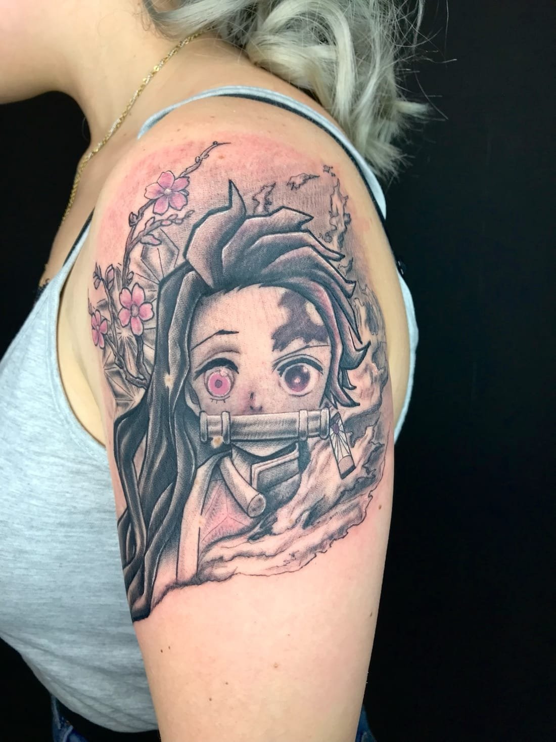 Nezuko, personnage de Demon Slayer, tatouée en réalisme noir et gris sur l'épaule
