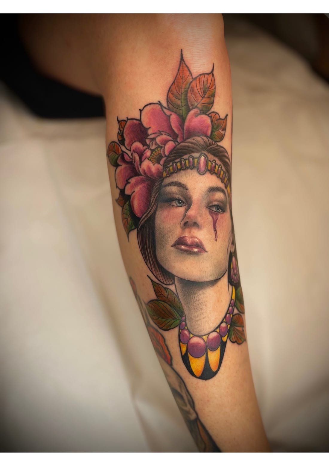Portrait féminin couronné de fleurs, tatouage couleur nouvelle école
