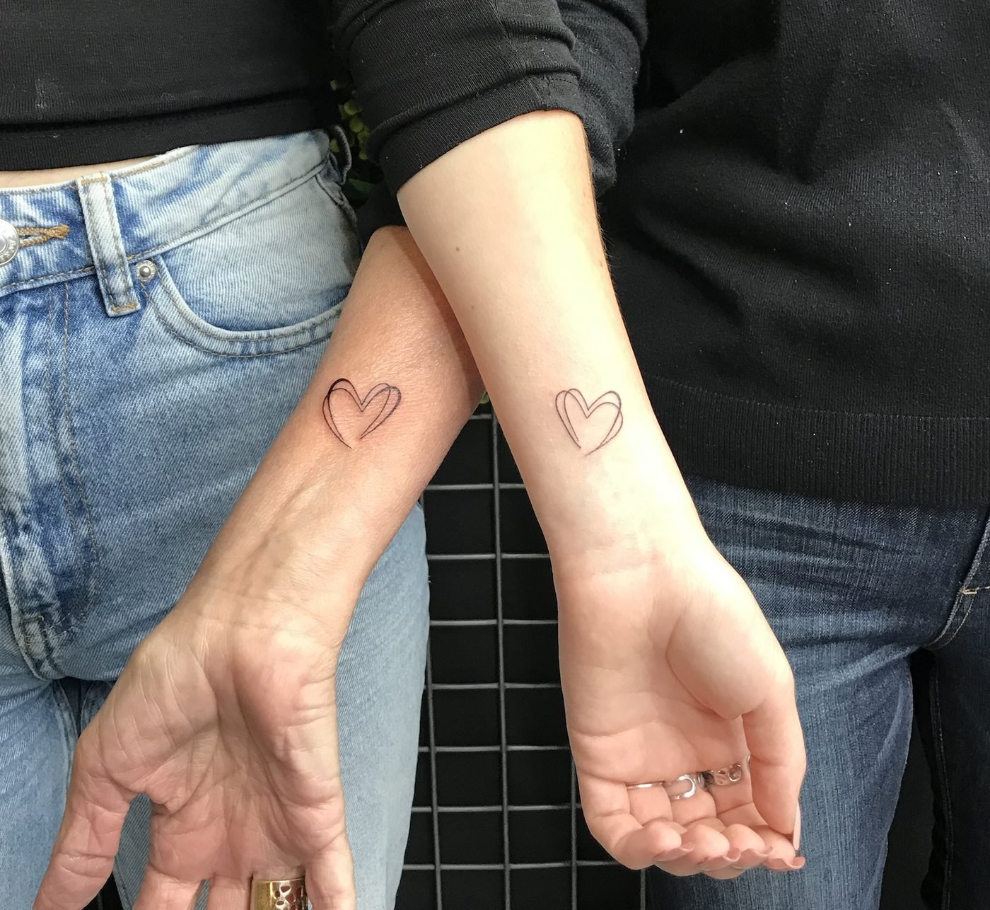 Tatouage en commun : deux petits cœurs en trait fin sur les poignets d’une grand-mère et de sa petite-fille
